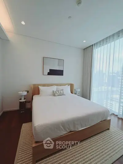 Modern bedroom with large window and stylish decor in a luxury apartment.