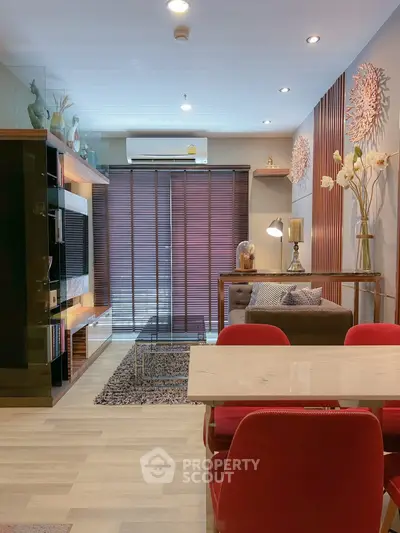 Modern living room with stylish decor and red chairs, featuring a cozy seating area and elegant lighting.