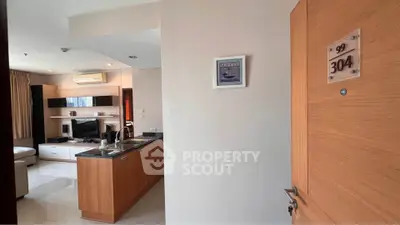 Modern apartment entrance with open kitchen and cozy living area, perfect for urban living.