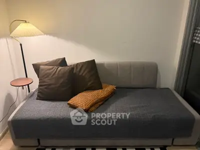 Cozy living room with stylish sofa and elegant floor lamp, perfect for relaxation.