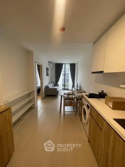 Modern open-plan kitchen and living area with natural light and stylish furnishings.