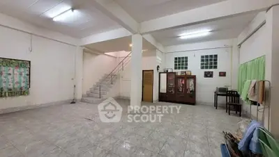 Spacious open-plan living area with tiled flooring and staircase, ideal for customization.
