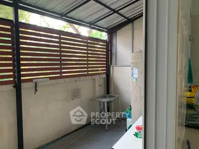 Cozy balcony with partial roof and garden view, perfect for relaxation.