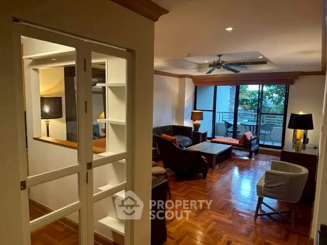 Spacious living room with elegant wooden flooring and balcony view