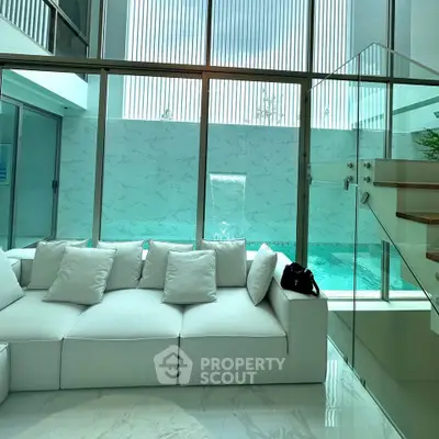 Luxurious modern living room with pool view and elegant white sofa