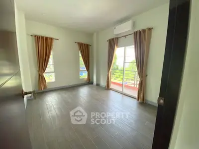 Spacious bedroom with large windows and balcony access, featuring elegant curtains and modern flooring.