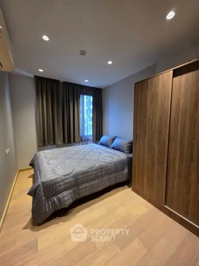 Cozy bedroom with modern decor and wooden flooring in a stylish apartment.