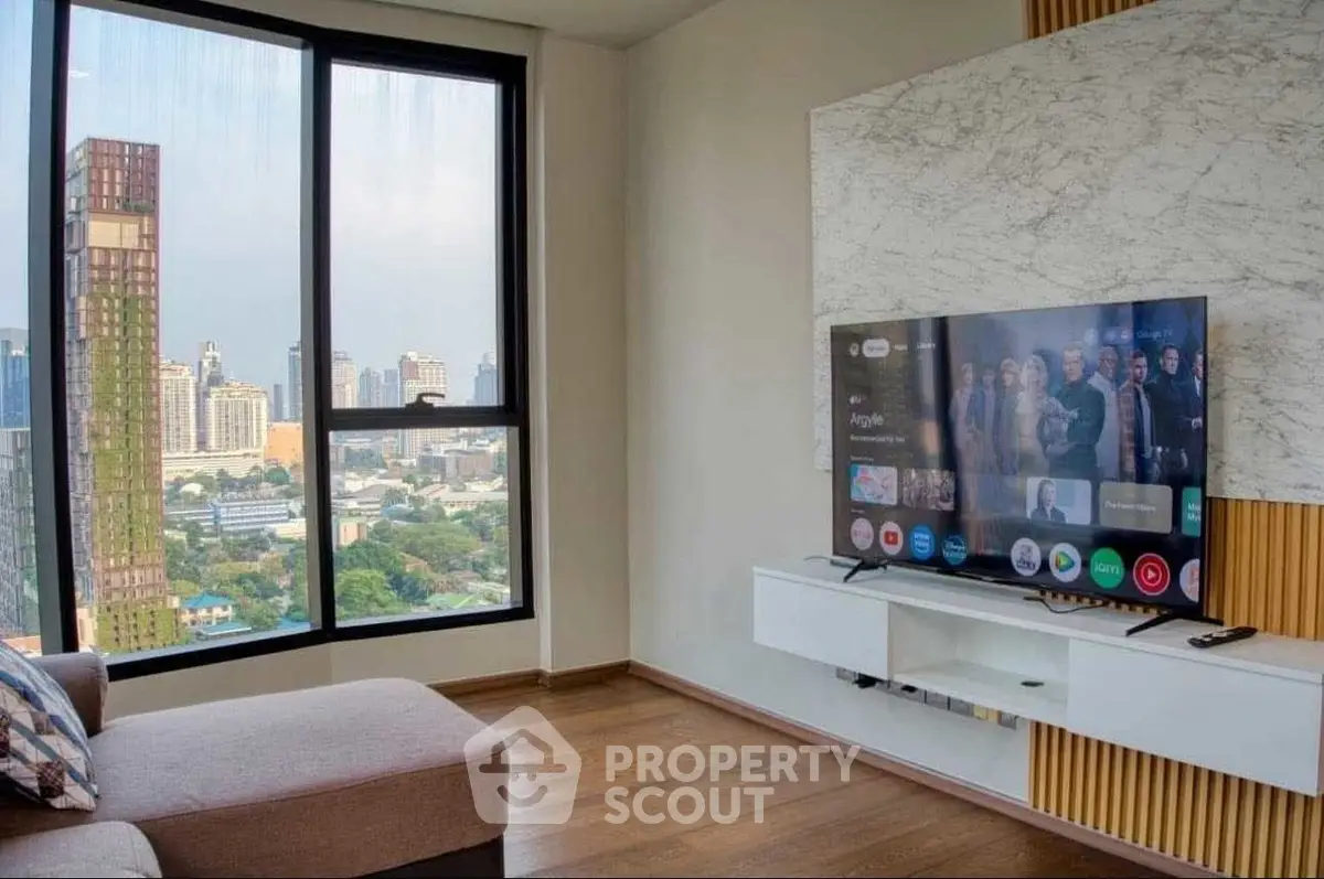 Modern living room with large window offering stunning city view and sleek entertainment setup.
