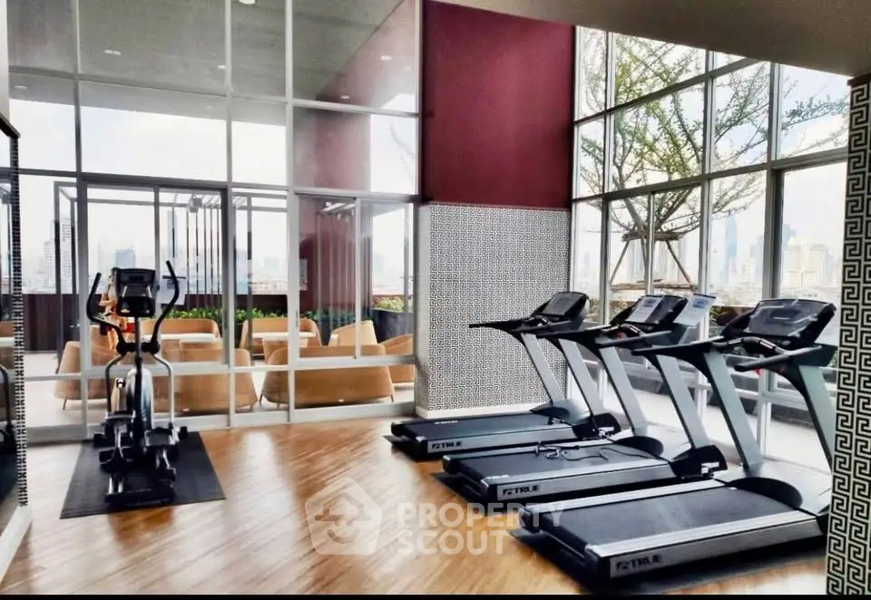 Modern gym with treadmills and city view in luxury apartment building