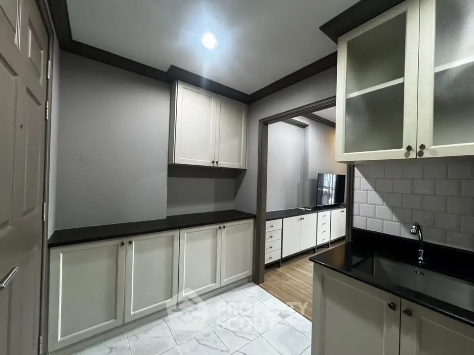 Modern kitchen with sleek cabinetry and black countertops in a stylish home.
