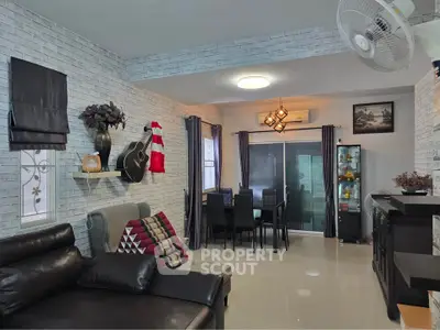 Stylish living room with modern decor and dining area, featuring sleek furniture and elegant lighting.