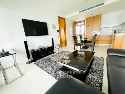 Modern living room with sleek furniture and open kitchen layout in a stylish apartment.