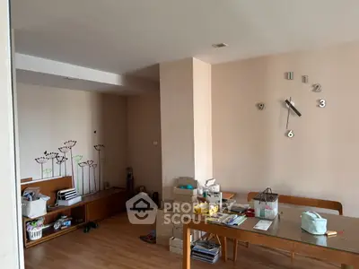 Spacious living room with modern decor and wall clock, perfect for family gatherings.