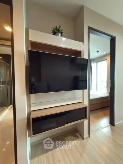 Modern apartment interior with sleek TV unit and cozy bedroom view