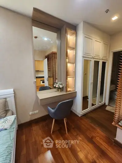 Modern bedroom with elegant wooden flooring and stylish built-in storage solutions.