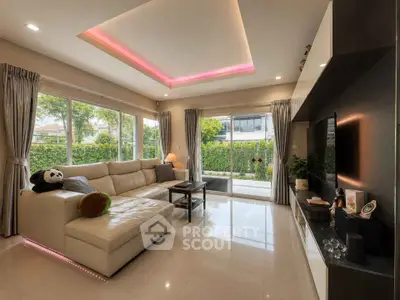Spacious modern living room with large windows and garden view, featuring elegant lighting and cozy seating.