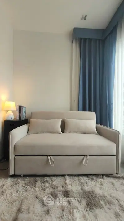 Cozy living room with plush sofa bed and elegant blue curtains