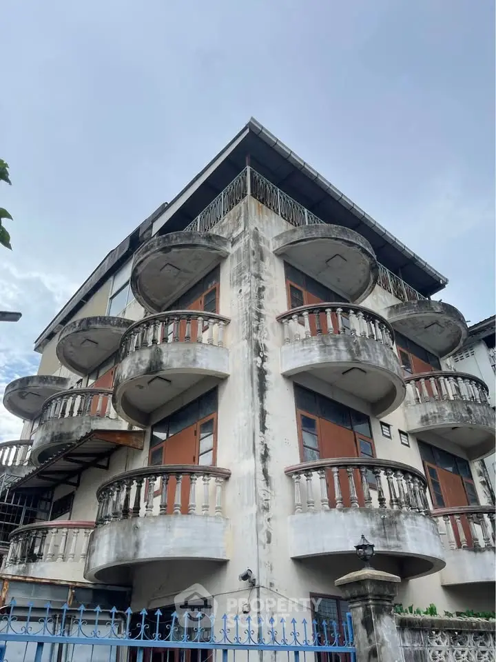 Charming vintage building with unique rounded balconies and classic architectural details.