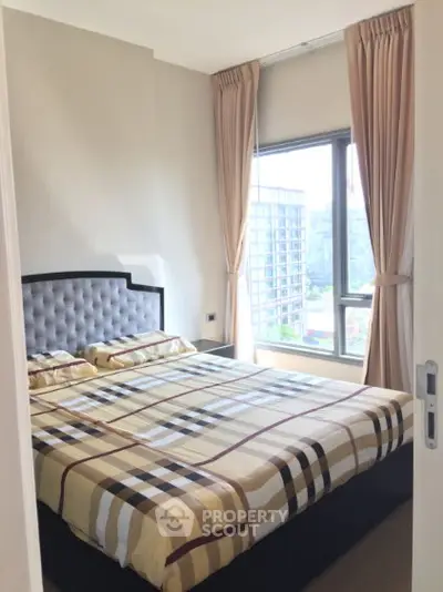 Cozy bedroom with large window and elegant curtains in modern apartment