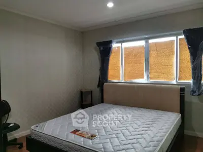 Spacious bedroom with large window and comfortable bed in modern apartment