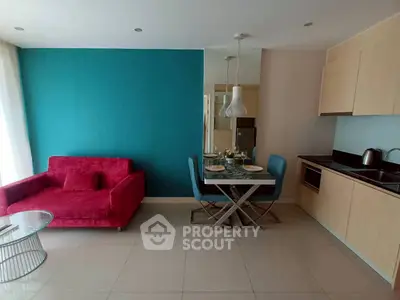 Modern living room with vibrant red sofa and sleek kitchen area