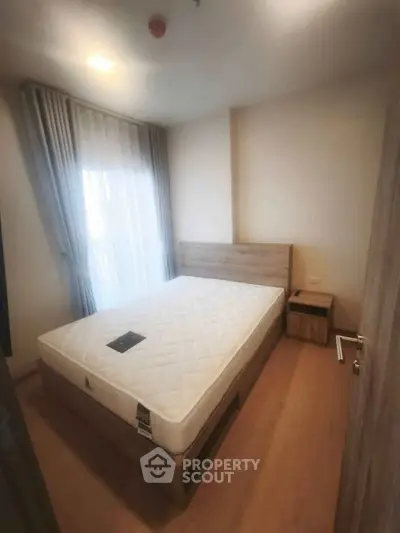 Cozy bedroom with natural light and modern furnishings, perfect for relaxation and comfort.