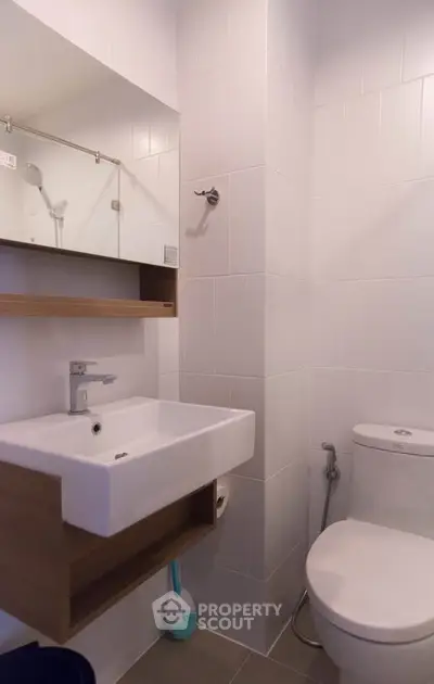 Modern bathroom with sleek white tiles and contemporary fixtures.