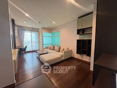 Spacious modern living room with elegant furniture and large windows offering natural light.