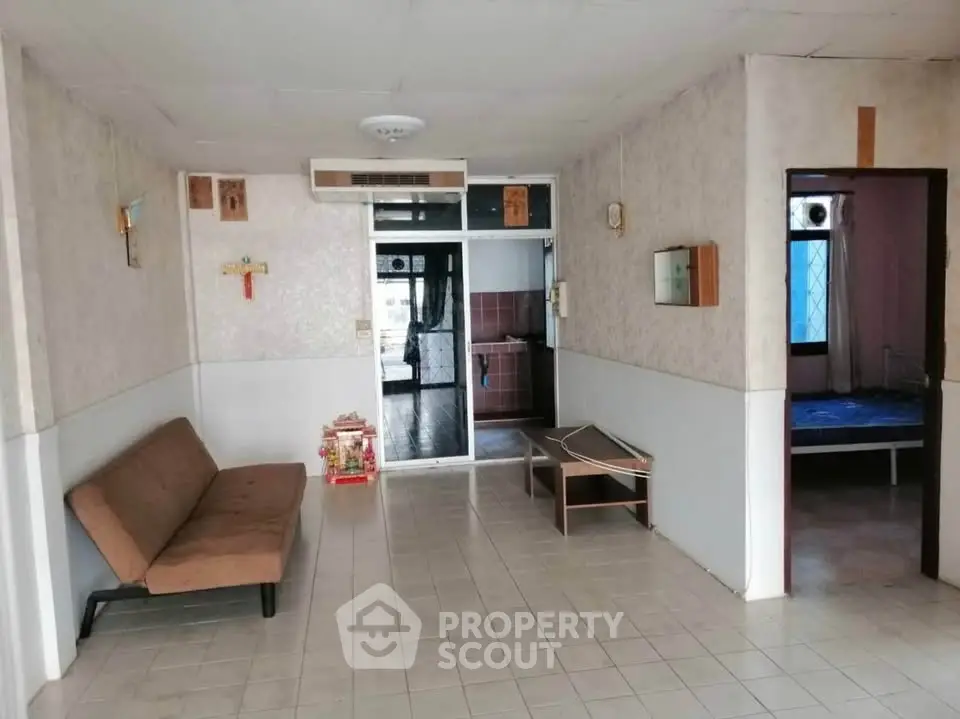 Spacious living room with sofa and tiled flooring in a cozy apartment.