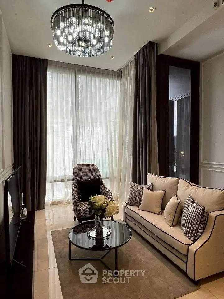 Elegant living room with modern chandelier, plush sofa, and floor-to-ceiling windows for natural light.