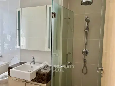 Modern bathroom with glass shower and sleek vanity in a contemporary apartment.