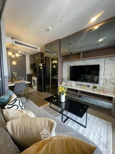 Modern living room with sleek furniture and open kitchen layout in a stylish apartment.