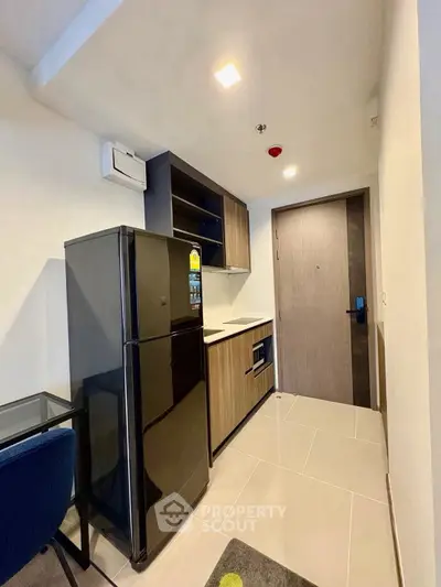 Modern compact kitchen with sleek appliances and stylish cabinetry in urban apartment