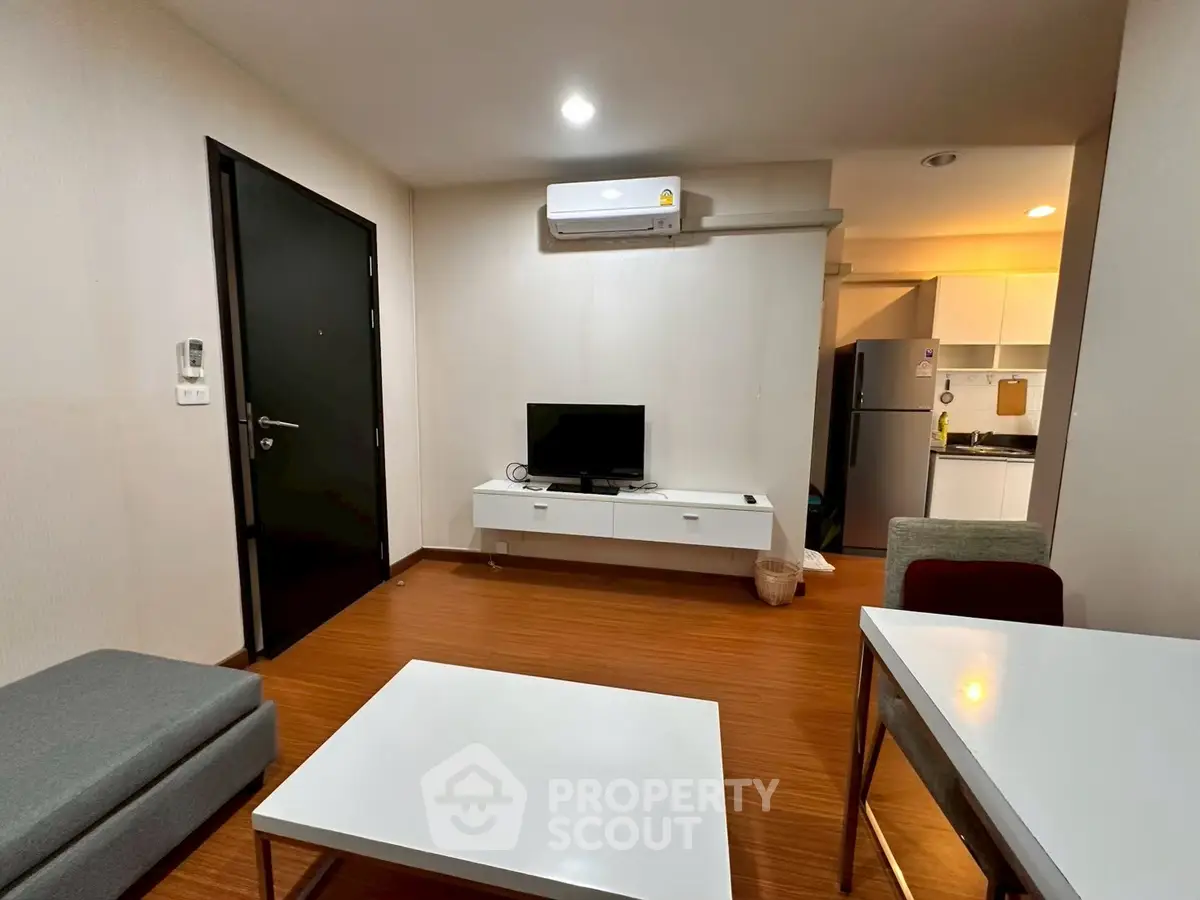 Modern living room with sleek furniture and open kitchen layout in a stylish apartment.