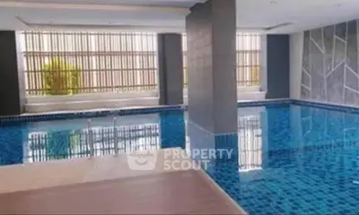 Luxurious indoor swimming pool with modern design and elegant finishes in a high-end residential building.