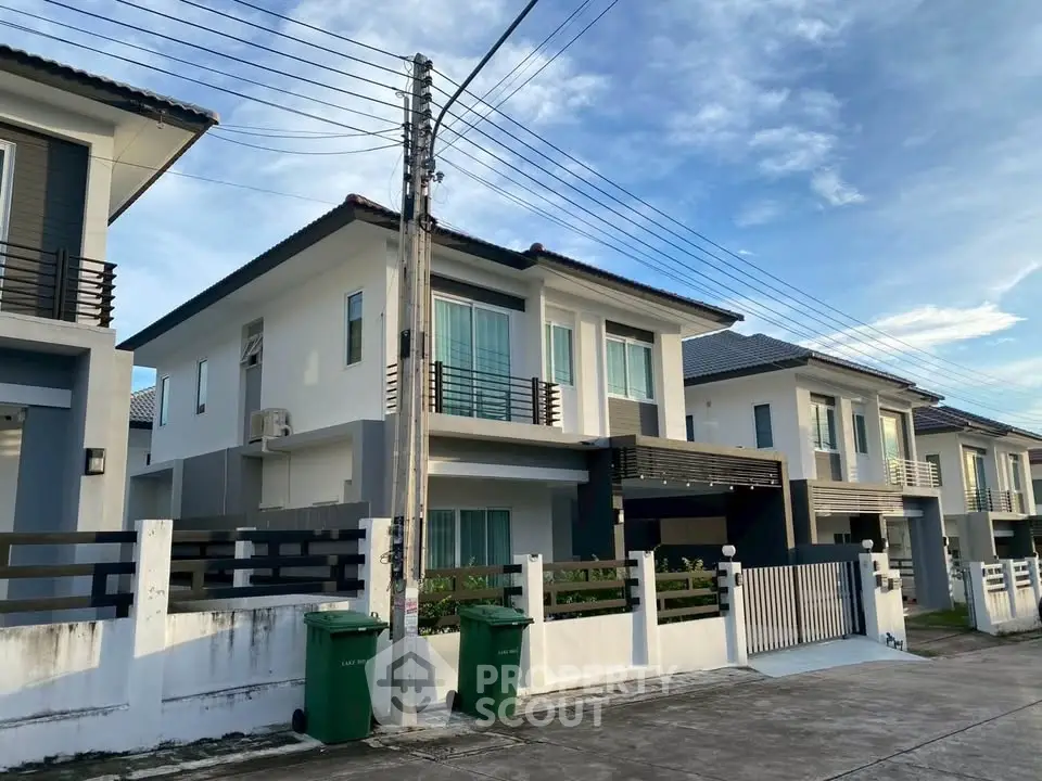 Modern two-story house with clean lines and spacious driveway in a suburban neighborhood.