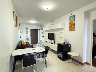 Modern living room with sleek furniture and wall-mounted TV in a cozy apartment.