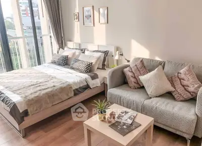 Cozy bedroom with stylish decor and natural light, featuring a comfortable bed and sofa.