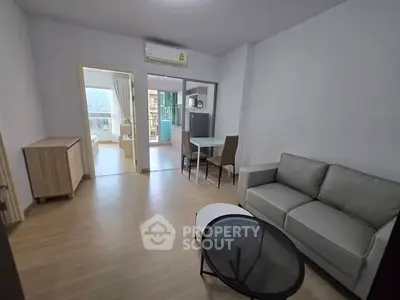 Spacious living room with modern furniture and natural light in a stylish apartment.