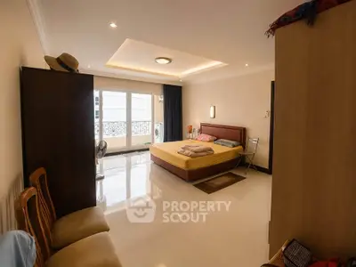 Spacious bedroom with modern decor and large windows offering natural light.