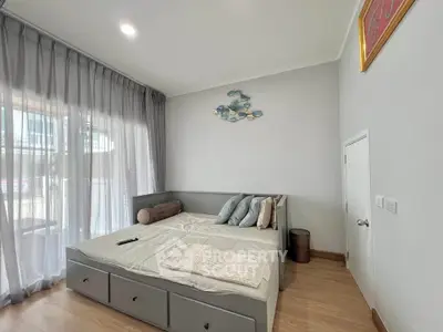 Cozy bedroom with modern decor and natural light, featuring a stylish bed and elegant curtains.