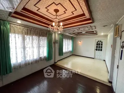 Spacious living room with elegant chandelier and large windows