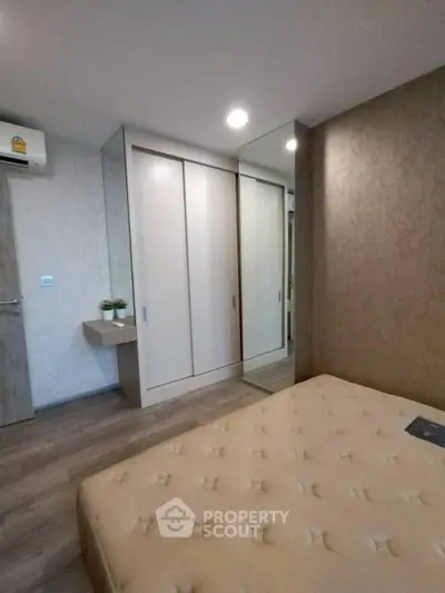 Modern bedroom with mirrored wardrobe and minimalist decor in a stylish apartment.