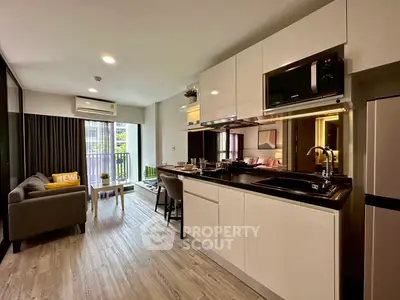 Modern open-layout kitchen and living room with sleek design and natural light.