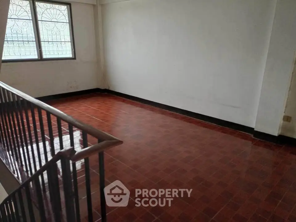 Spacious empty room with tiled floor and large window, ideal for customization.