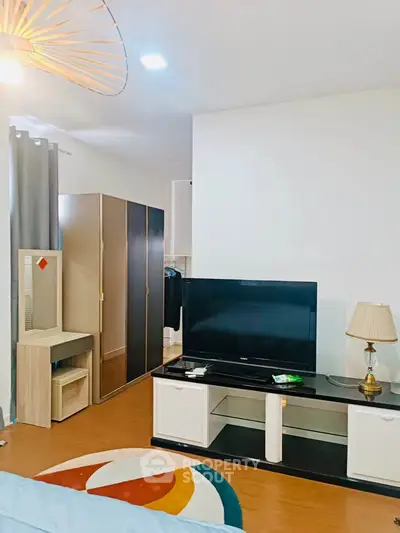 Modern living room with stylish furniture and large TV, perfect for relaxation and entertainment.