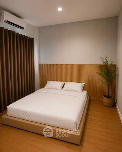 Modern minimalist bedroom with cozy bed and wooden flooring