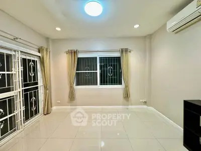 Spacious living room with large windows and modern lighting in a stylish apartment.