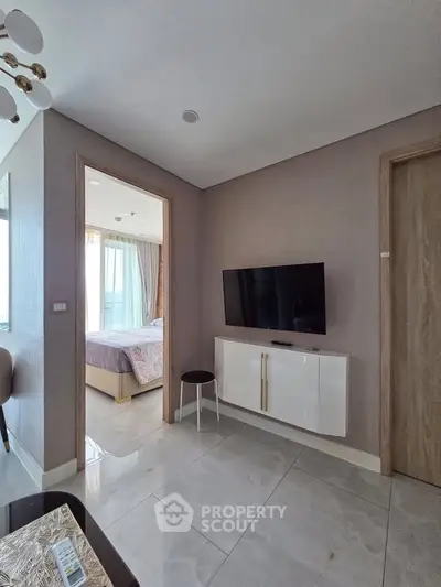 Modern apartment interior with TV and glimpse of bedroom