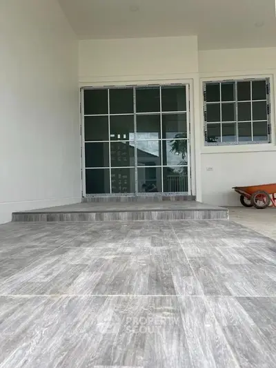 Modern entrance with sliding glass doors and tiled flooring